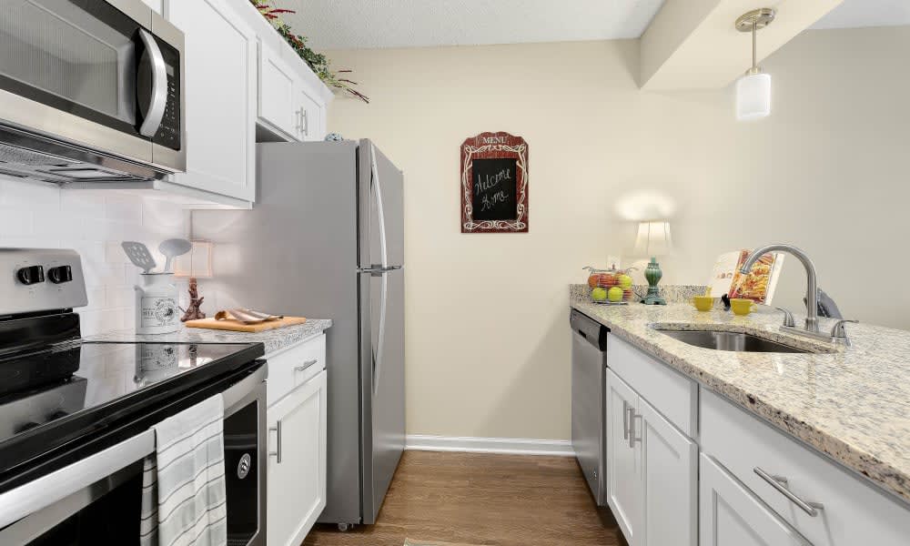 A modern kitchen with white cabinets and stainless steel appliances.