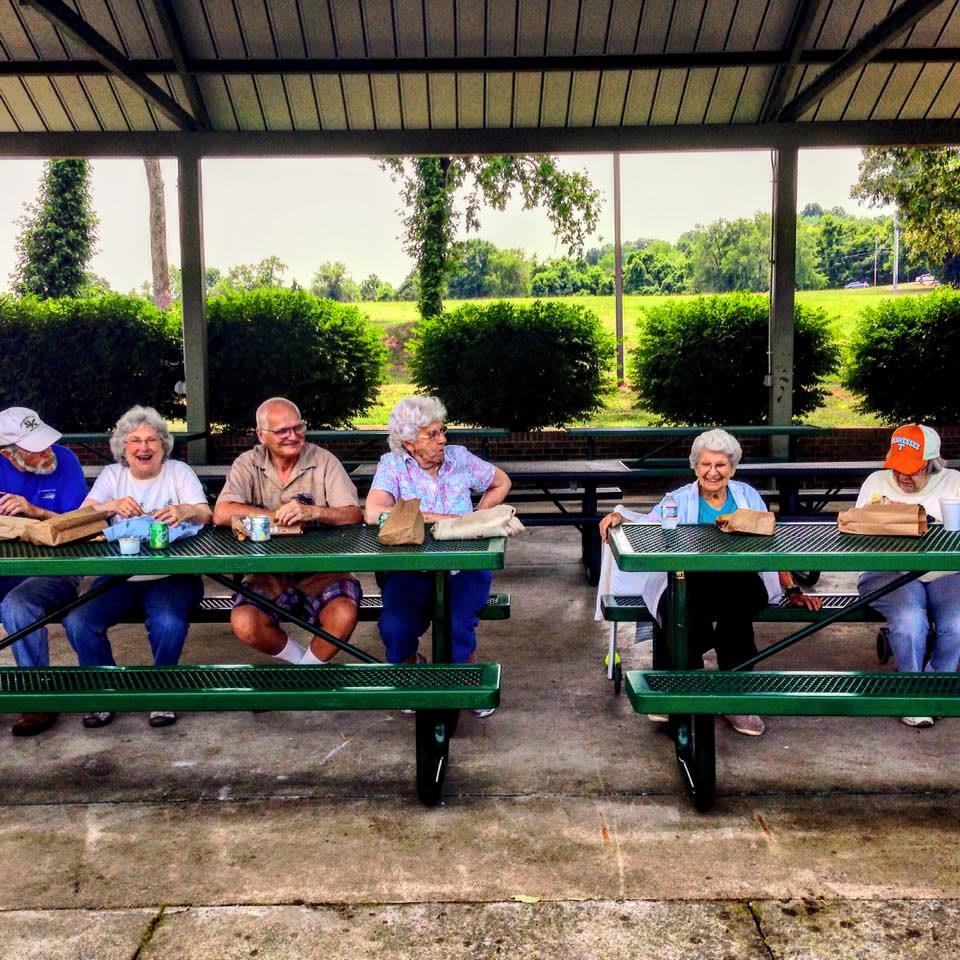A group of seniors enjoying a picnic under a pavilion.