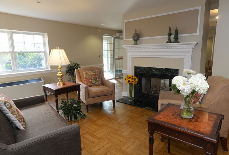 A cozy living room featuring a fireplace, armchairs, and tasteful decor.