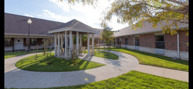 A scenic view of a building with a covered walkway and garden area.