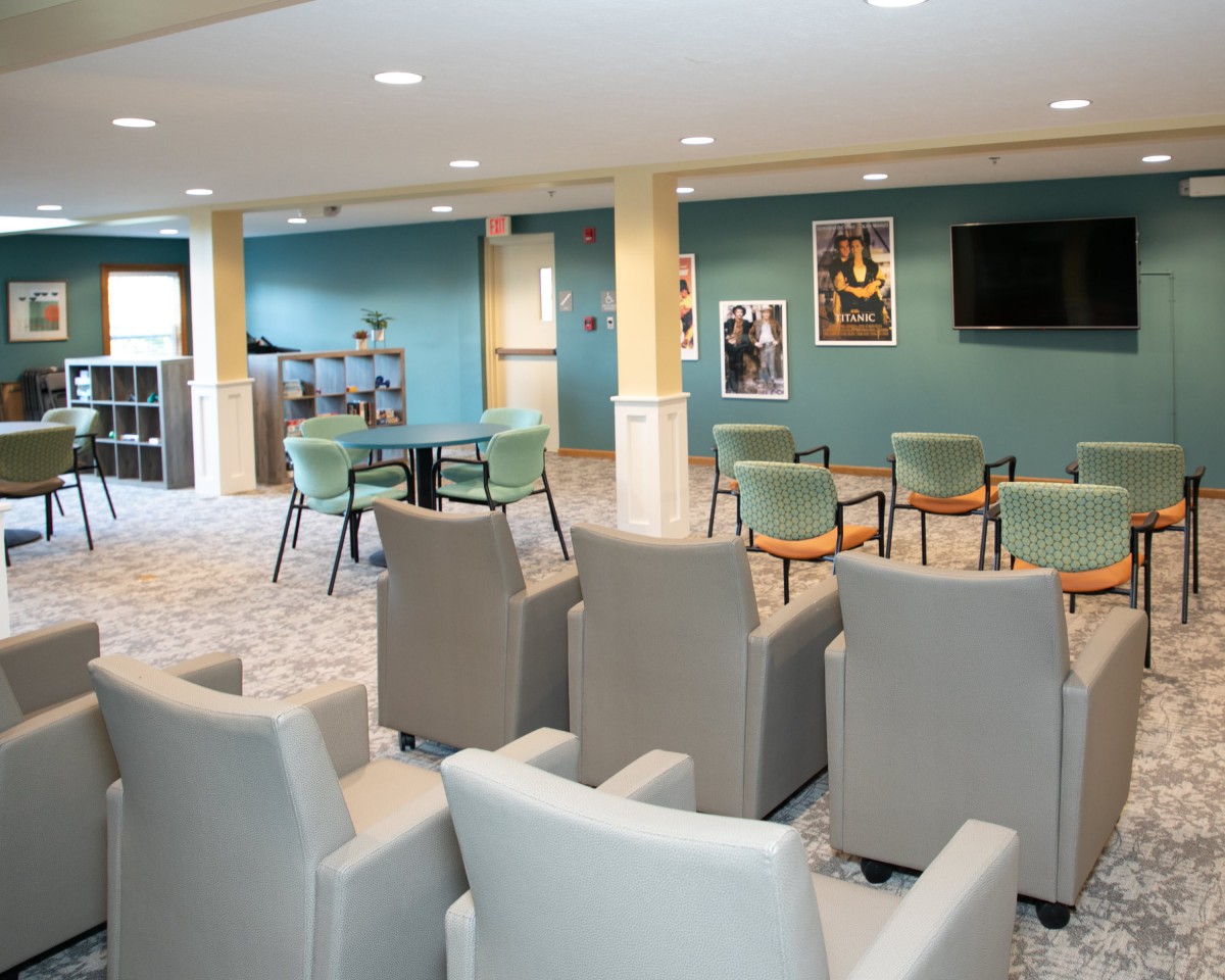 A modern lounge area with comfortable seating and a television for group meetings or relaxation.