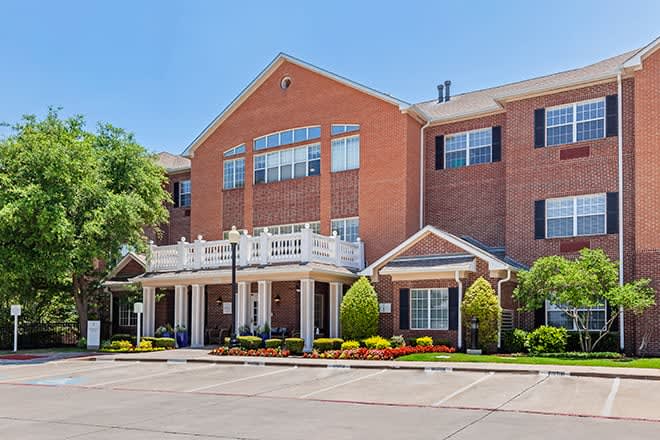 A residential brick building with a landscaped entrance.