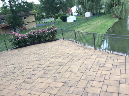 A serene outdoor patio area with flowers and a neatly maintained lawn.