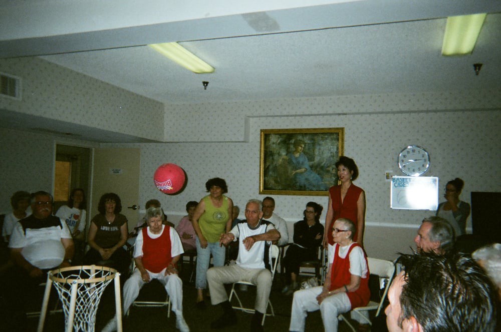 A group of seniors engaging in an indoor basketball activity at a community center.