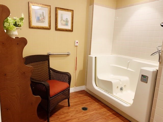 A cozy bathroom with a walk-in tub and a comfortable chair.