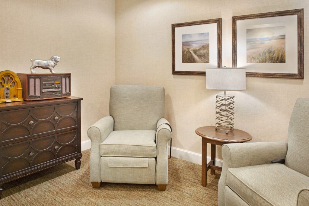 Cozy living room corner with armchairs, a side table, and artwork.