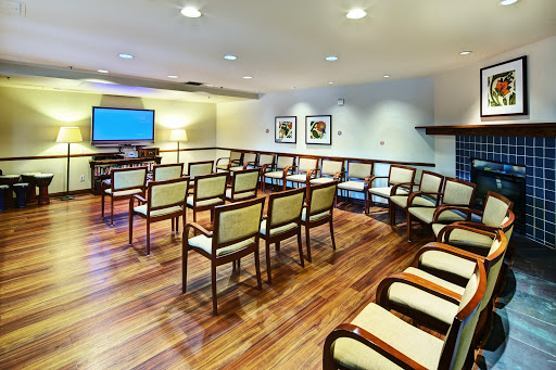 A well-designed waiting room featuring comfortable chairs and a modern television setup.