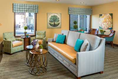 A cozy living room with stylish furniture and decor, featuring a large sofa, colorful cushions, and modern artwork.