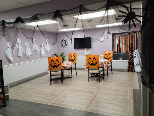 A festive Halloween-themed dining area featuring pumpkin-decorated chairs and spooky decorations.