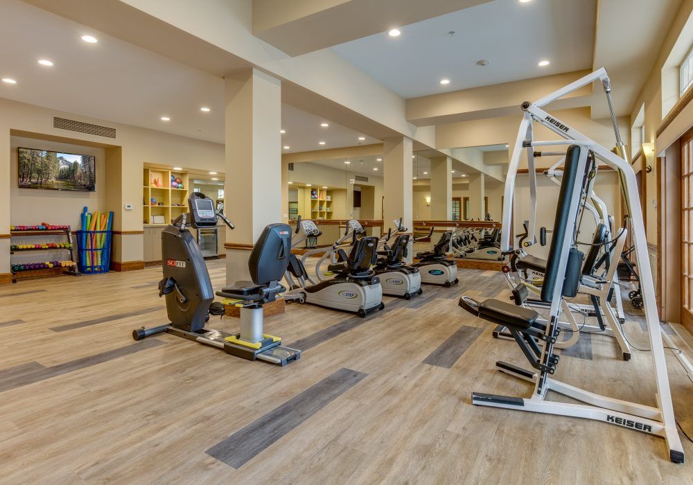 A spacious gym with various exercise machines including treadmills and stationary bikes.
