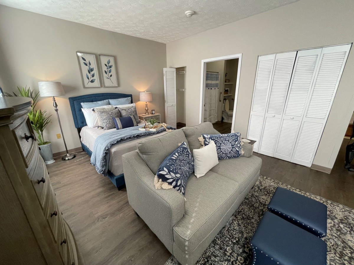 A cozy bedroom with a bed, sofa, and stylish decor.
