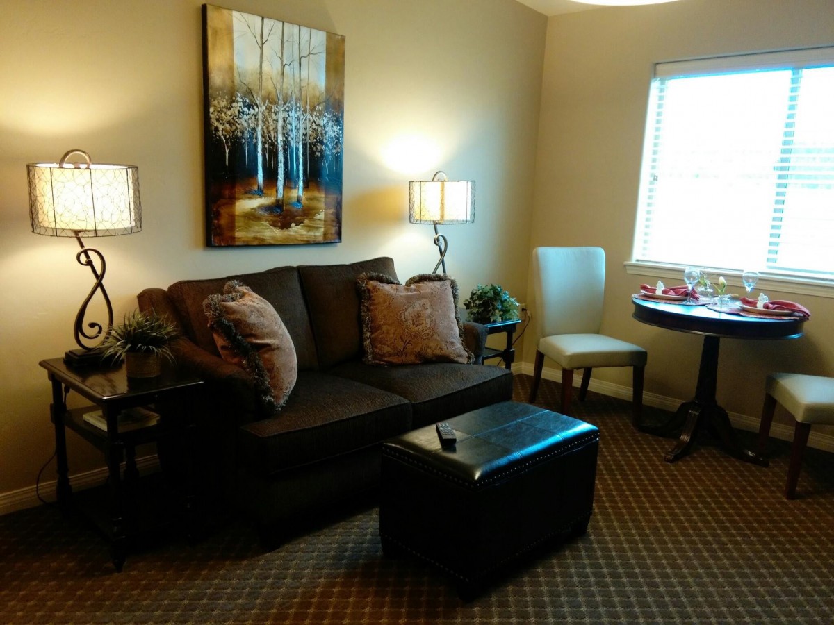 A cozy living room featuring a comfortable sofa, artistic wall decor, and warm lighting.