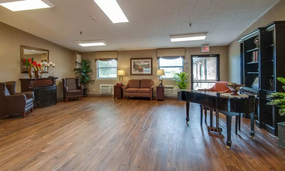 A spacious room with comfortable seating and a piano.