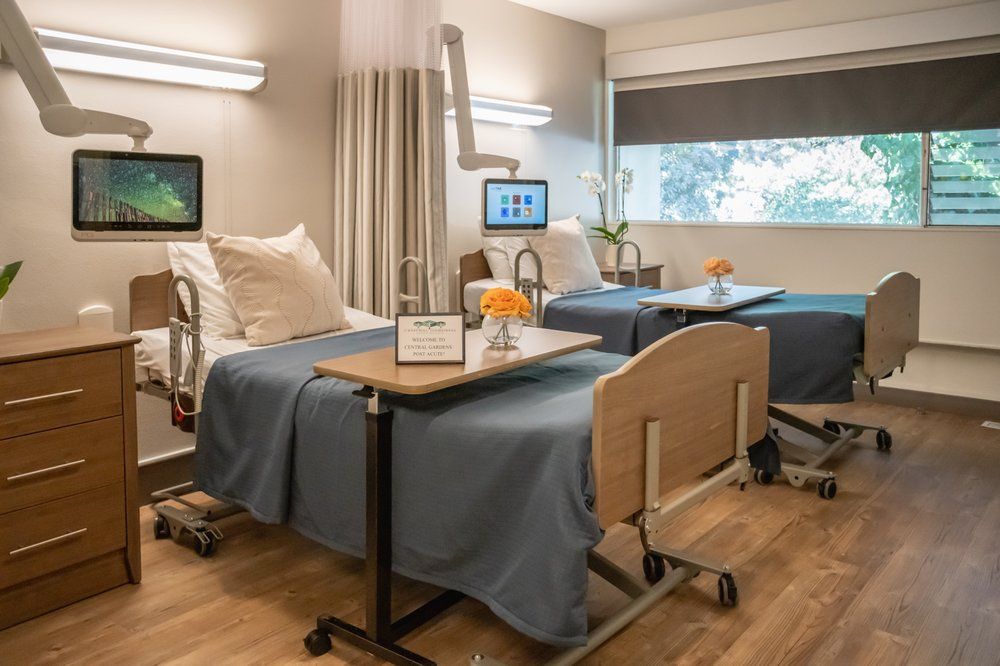A modern hospital room with two patient beds and comfortable amenities.