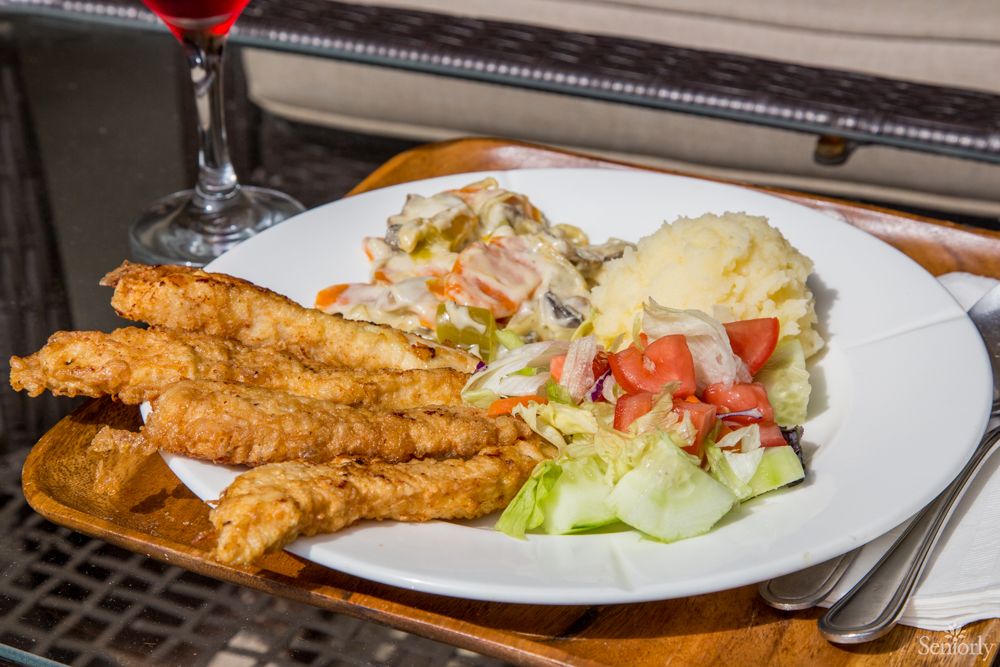 A delicious meal featuring fried chicken, mashed potatoes, and a fresh vegetable salad.