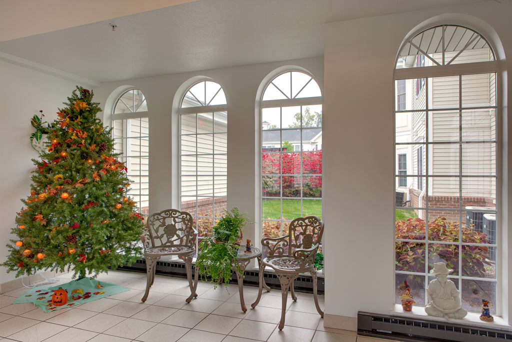 A bright conservatory with a seating area and garden view.