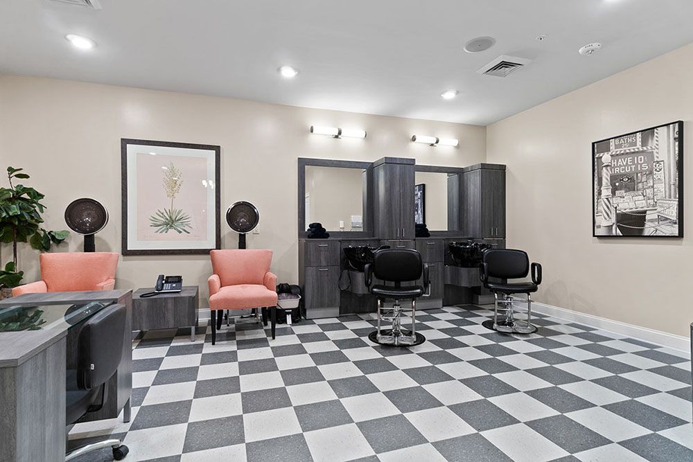A cozy hair salon with a checkered floor, featuring styling stations and a comfortable waiting area.