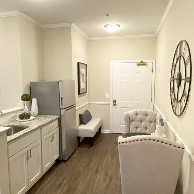 A cozy kitchenette with modern decor, featuring a small seating area and compact appliances.