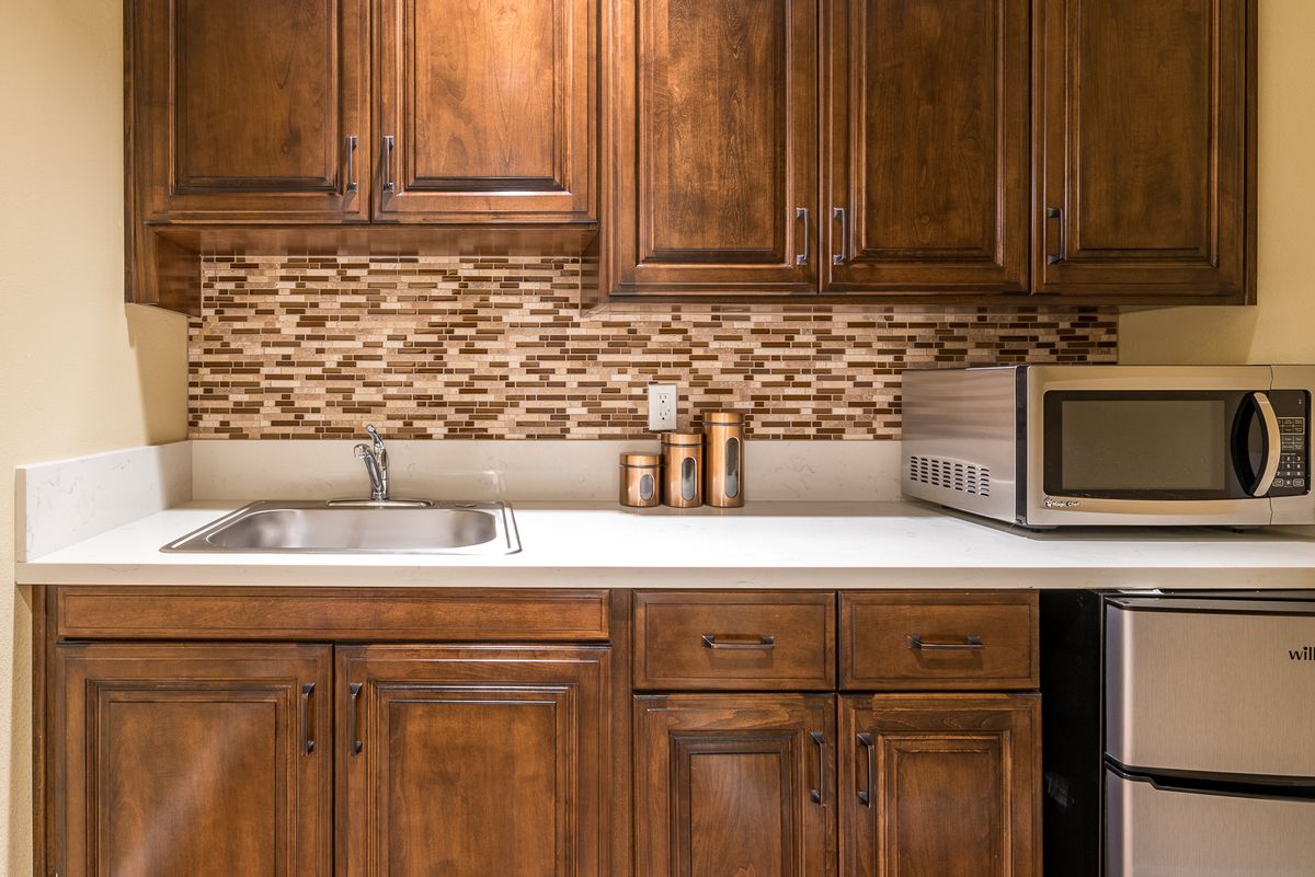 A kitchen with wooden cabinets, a countertop, and modern appliances.
