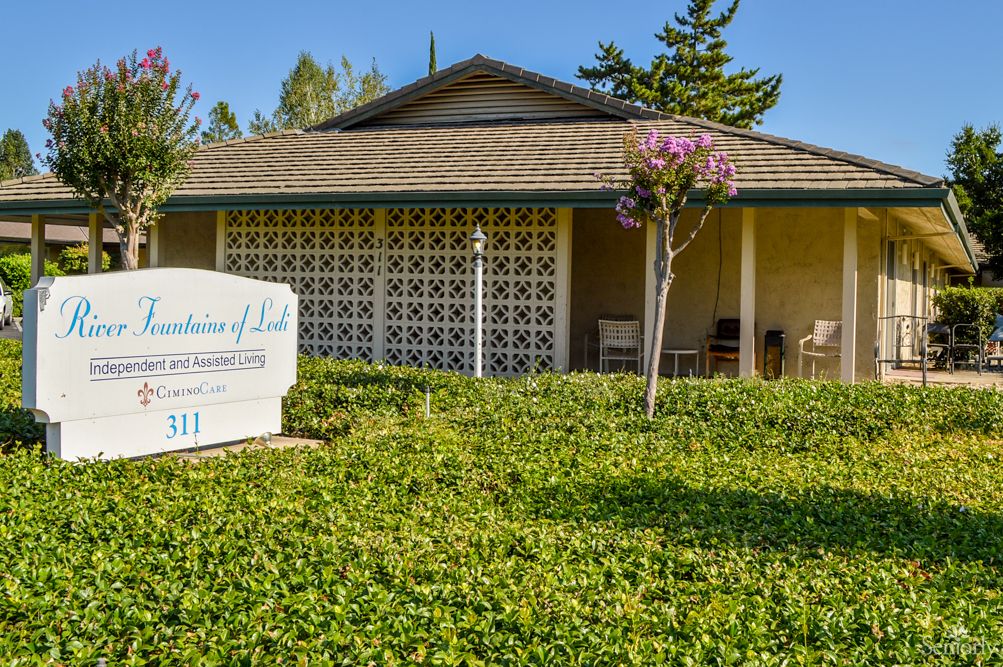 A healthcare clinic surrounded by greenery with a visible signboard.