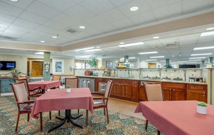 An empty dining area with tables, chairs, and a buffet setup.