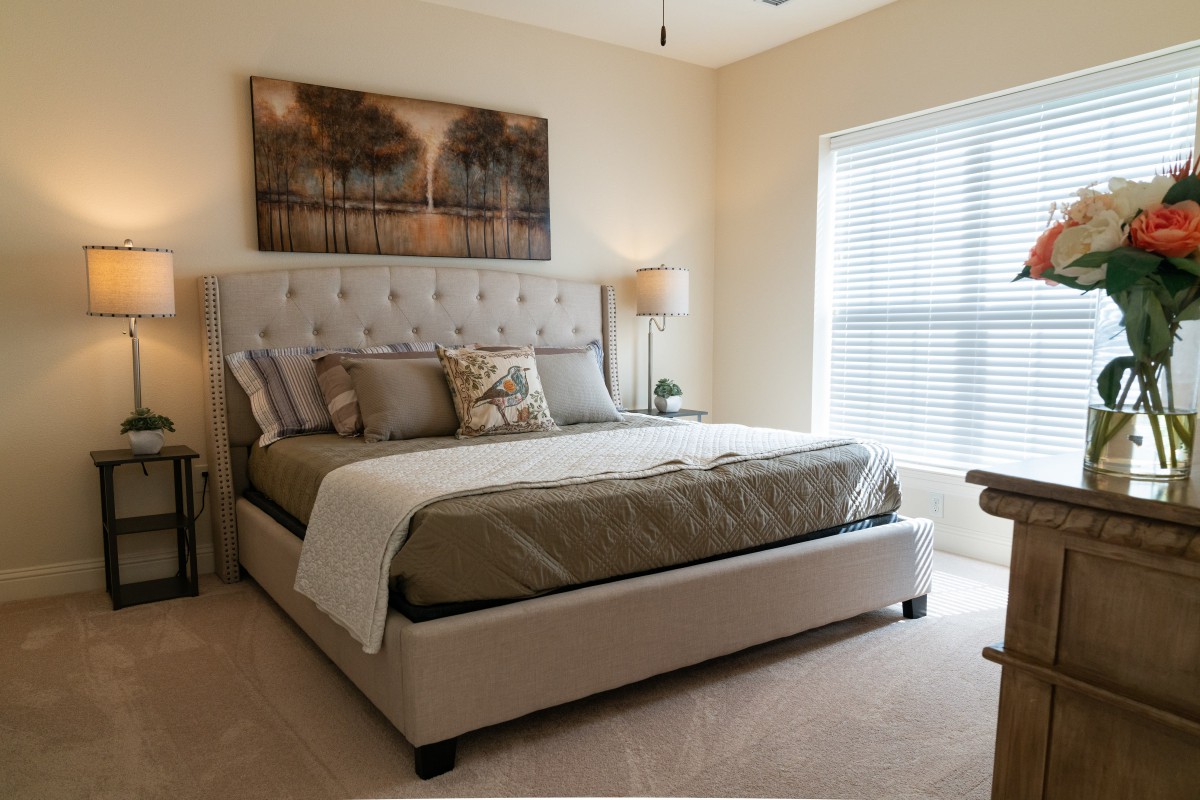 A cozy, well-decorated bedroom featuring a large bed and soft lighting.