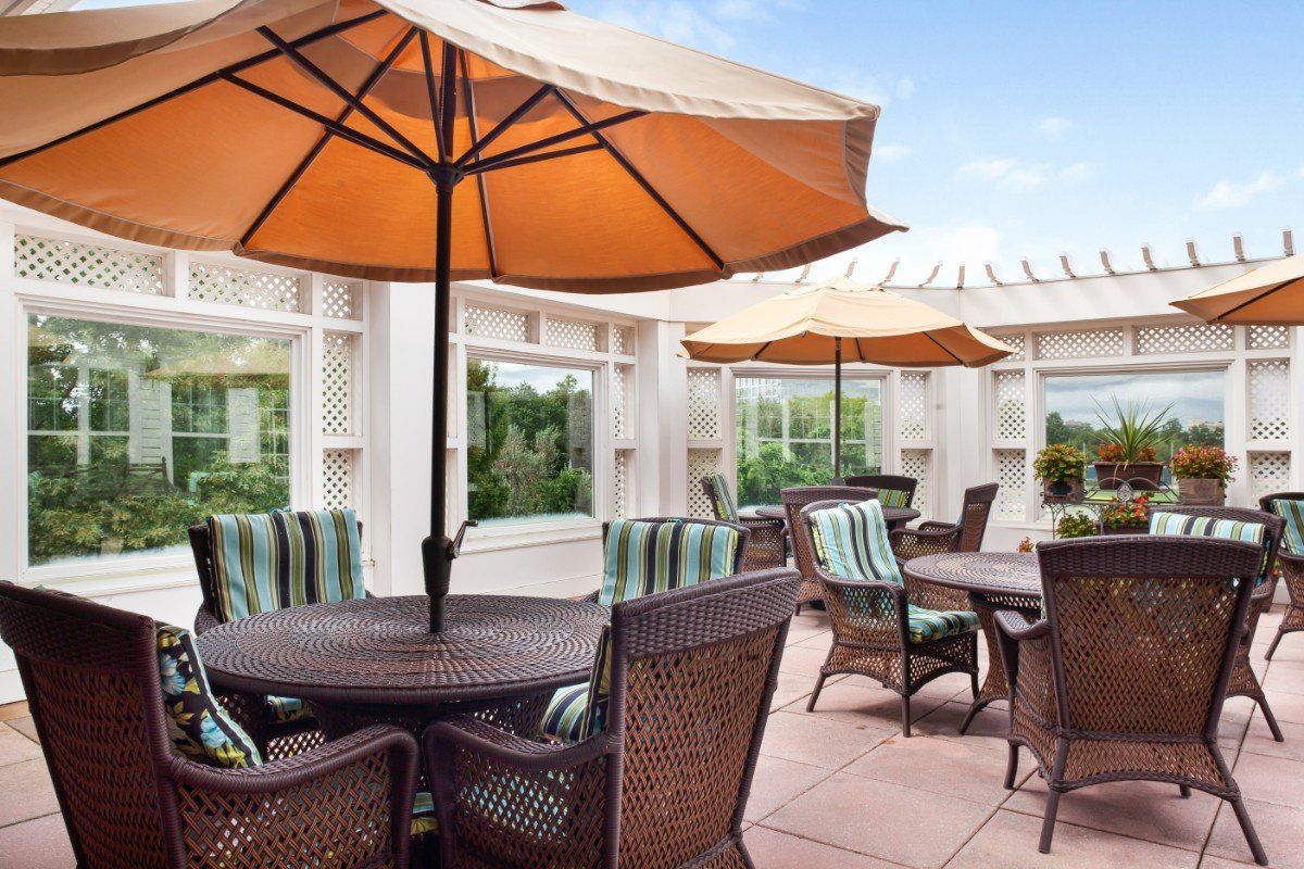 A cozy outdoor patio with tables and chairs under large umbrellas.
