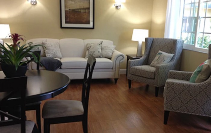 A cozy living room with a sofa, chairs, and a table.