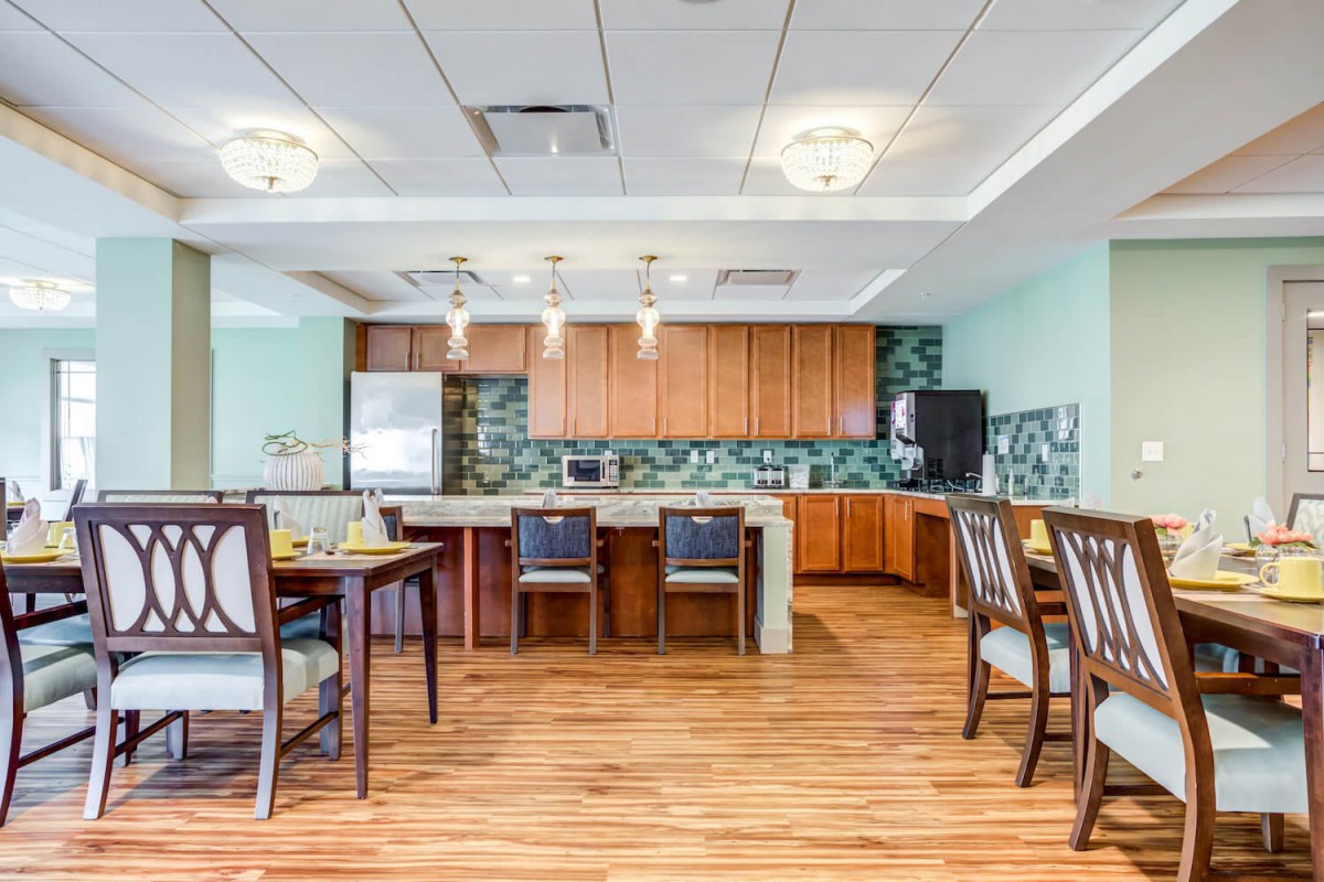 A modern kitchen and dining area with wooden flooring and stylish ceiling lights.