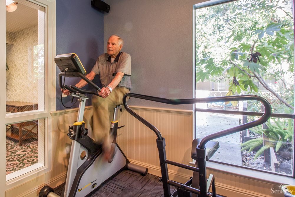 A person exercises on a stationary bike indoors.