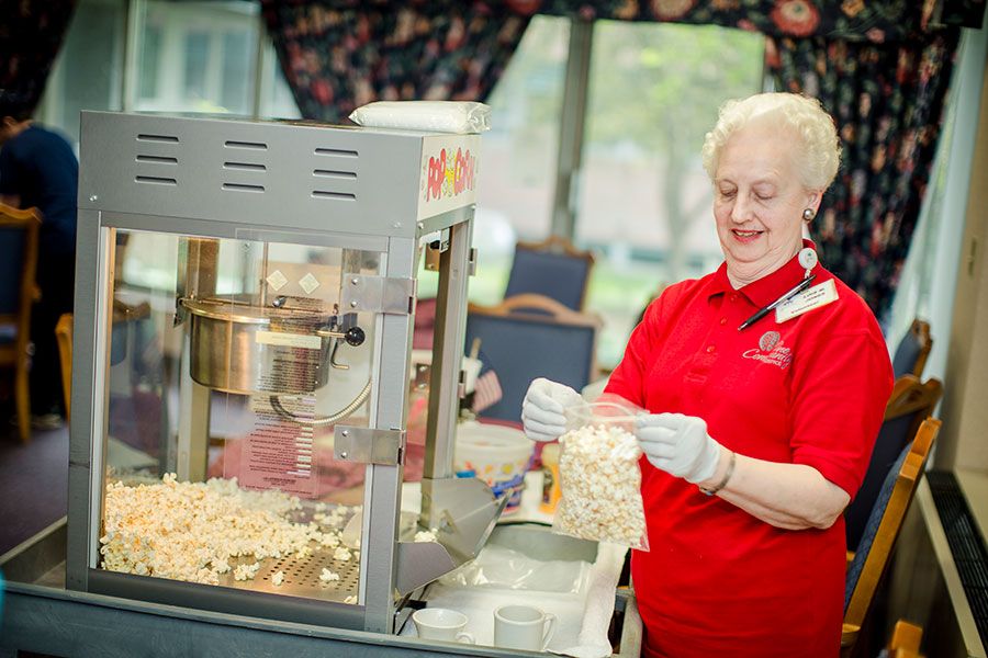 A person preparing popcorn using a machine at an indoor event.