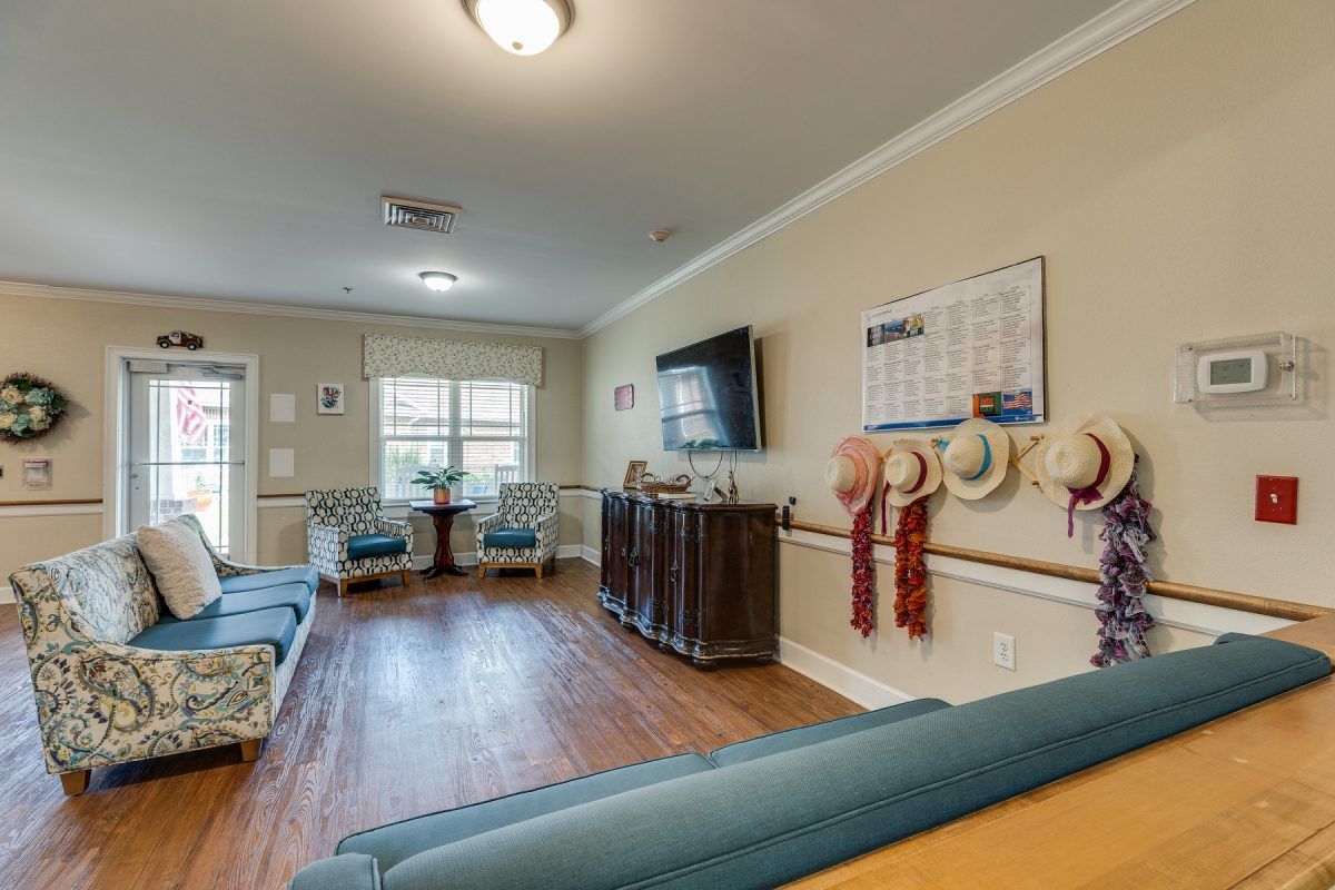 A cozy living room with seating, a television, and various decorations.