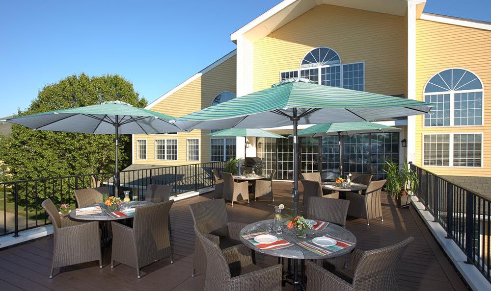 An inviting outdoor patio area with tables and umbrellas under a clear blue sky.