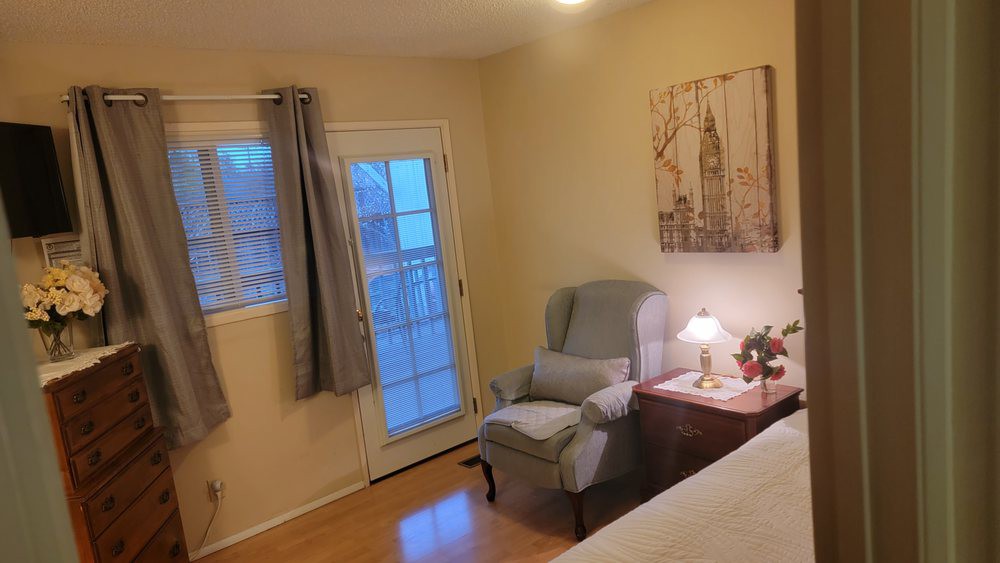 Cozy bedroom with a comfortable chair and soft lighting.