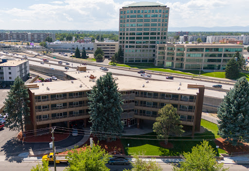 Aerial view of a city area featuring modern buildings and green landscaping.