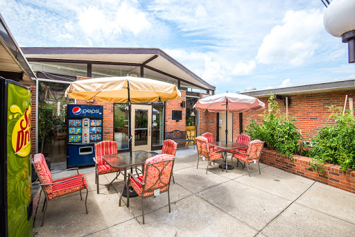 A cozy outdoor seating area with colorful umbrellas, perfect for enjoying a drink on a sunny day.