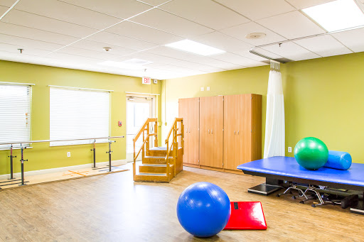 A bright and spacious physical therapy room equipped with various exercise tools and facilities.