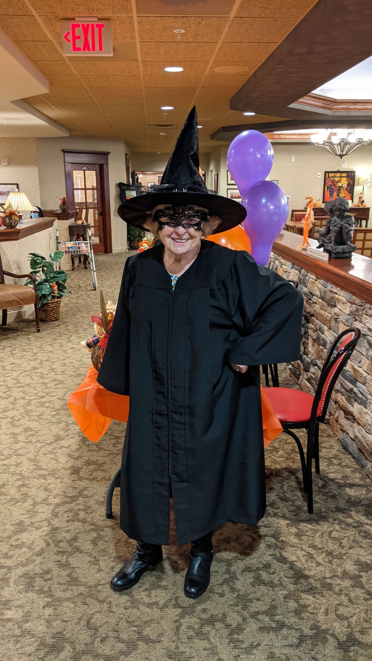 Person in a witch costume celebrating Halloween indoors.