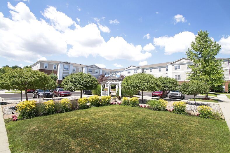 A residential building with a landscaped garden and clear blue sky.