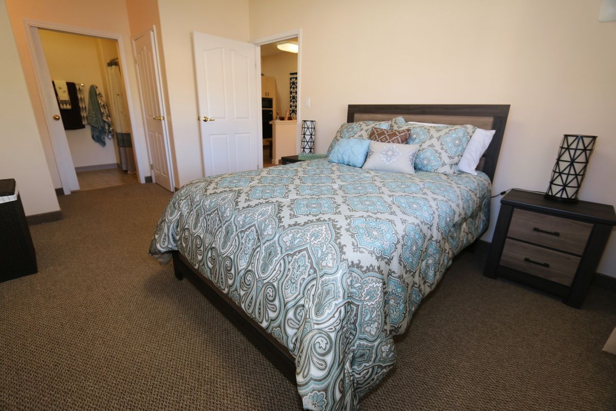 A cozy bedroom with a neatly made bed and decorative pillows.