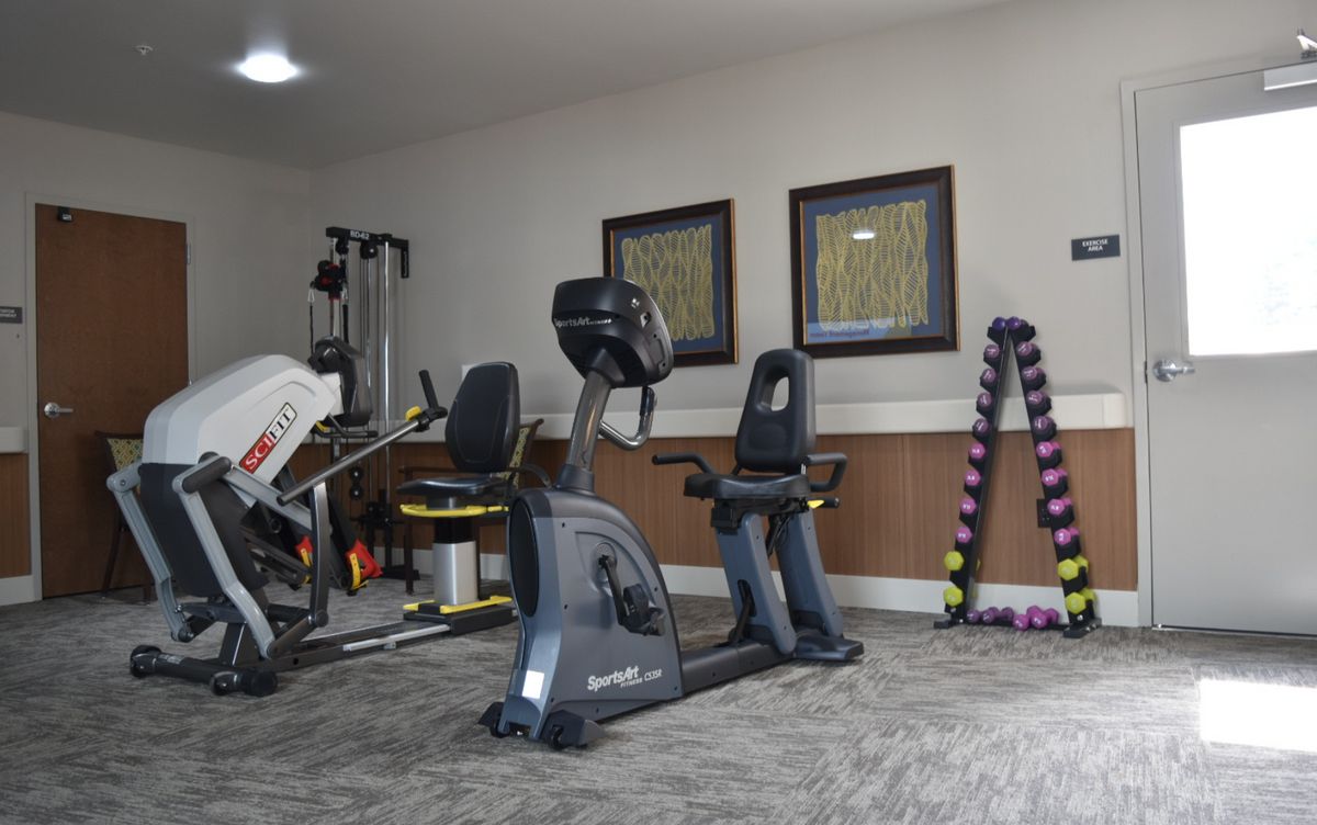 A well-equipped home gym featuring exercise machines and weights.