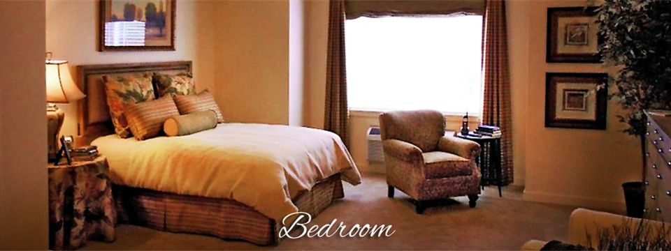A cozy bedroom with a bed and an armchair near a window.