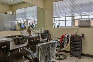 Interior view of a barber shop with chairs and equipment.