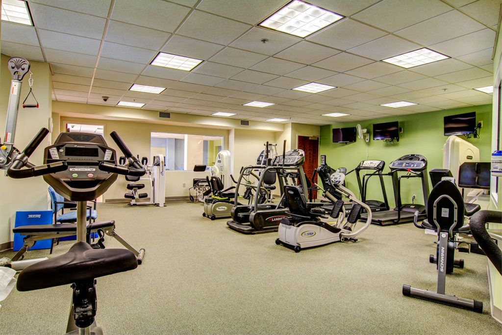 A well-equipped gym featuring various exercise machines including treadmills and stationary bikes.