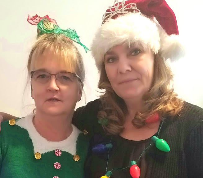 Two people dressed in festive Christmas attire.