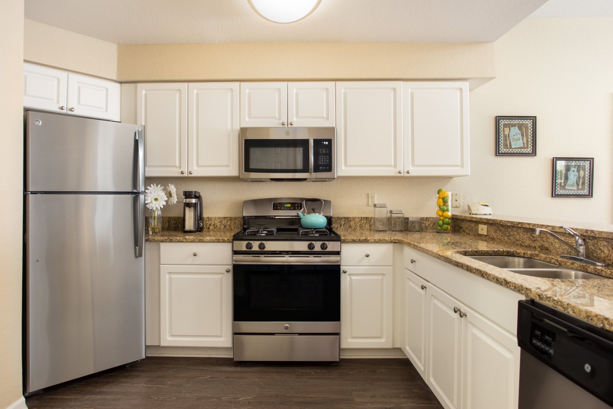 A modern kitchen with white cabinets and stainless steel appliances.