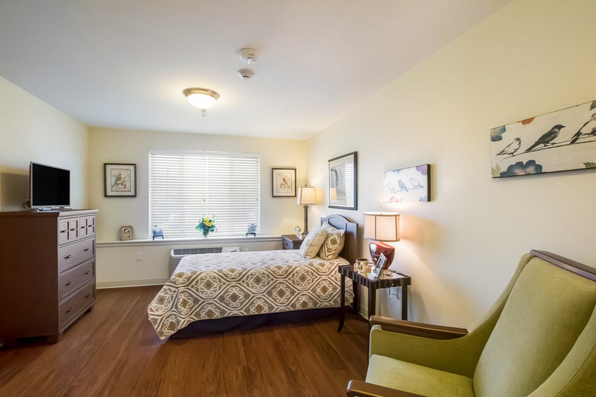 A cozy bedroom interior with a neatly made bed, soft lighting, and elegant decor.