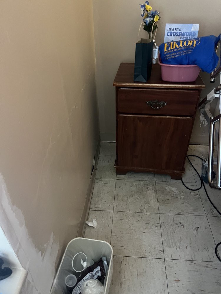 A small corner featuring a wooden cabinet with various items on top.