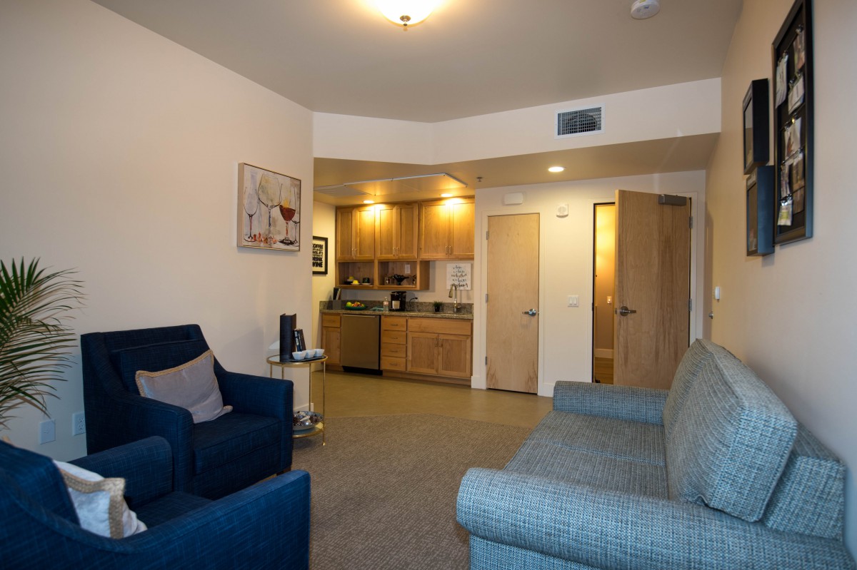A cozy living area featuring a small kitchen and comfortable seating.
