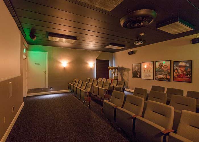 An empty movie theater with rows of seats and dim lighting.
